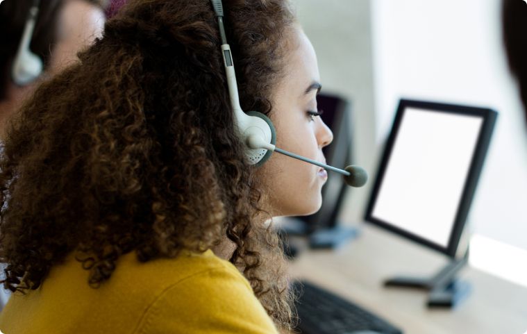 Answering service agent in front of computer at a business virtual reception desk performing 24/7 live answering services