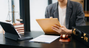 Legal pad and case materials being handled by a young lawyer working for a law firm with a 24/7 legal intake service