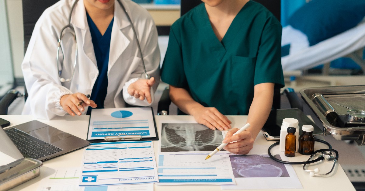 medical team reviewing patient records at a table.
