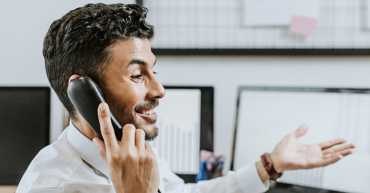happy businessman talking on the phone in an office setting.