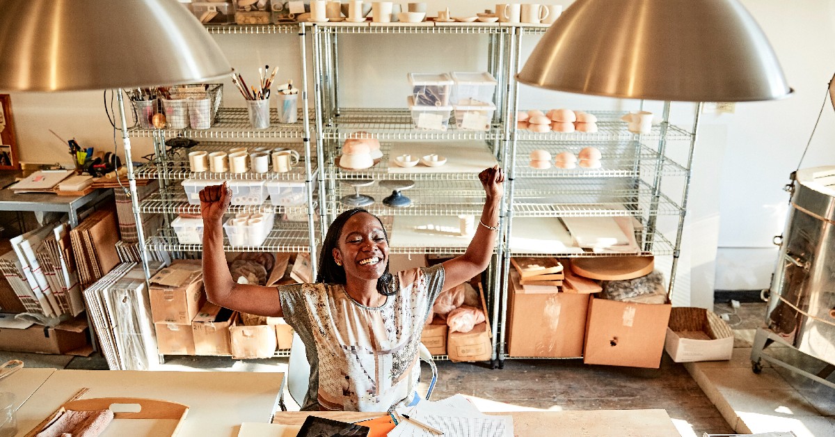 Small business owner cheering at the success of her small business.