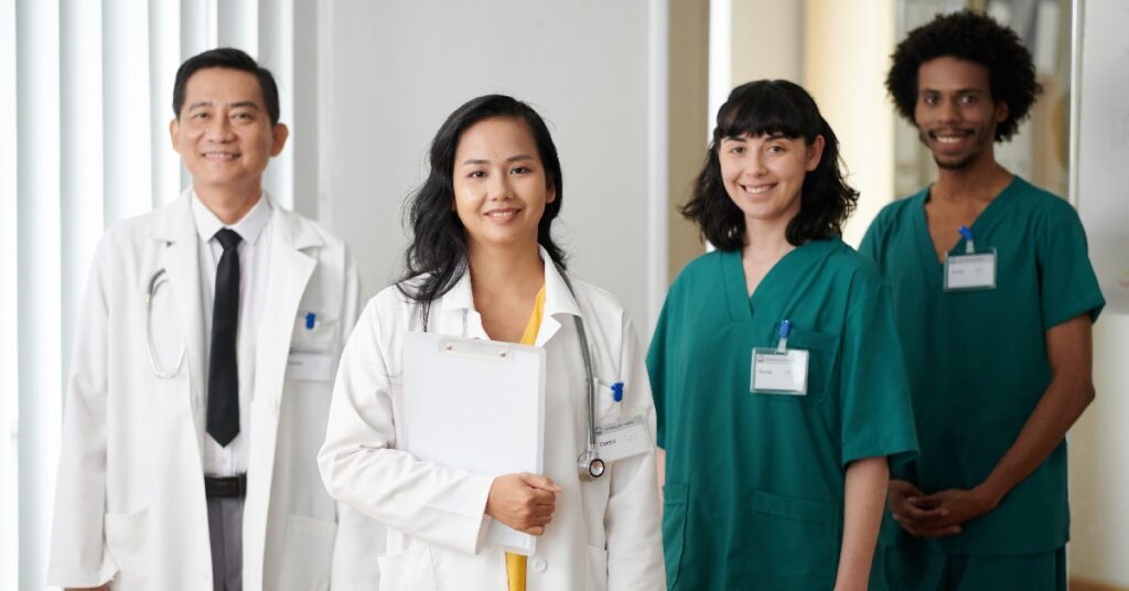 Team of smiling doctors in a row working at a medical practice.