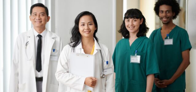 Team of smiling doctors in a row working at a medical practice.